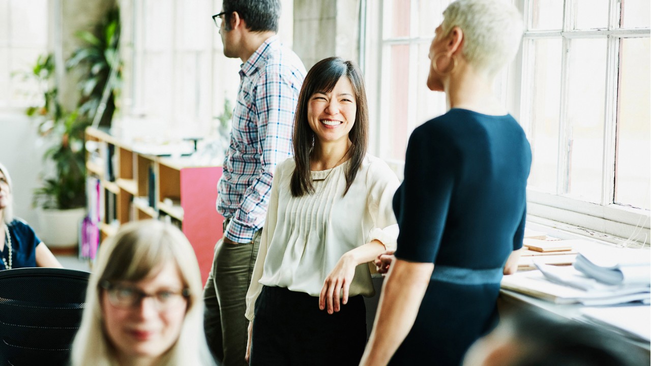 Smiling coworkers in discussion in design studio